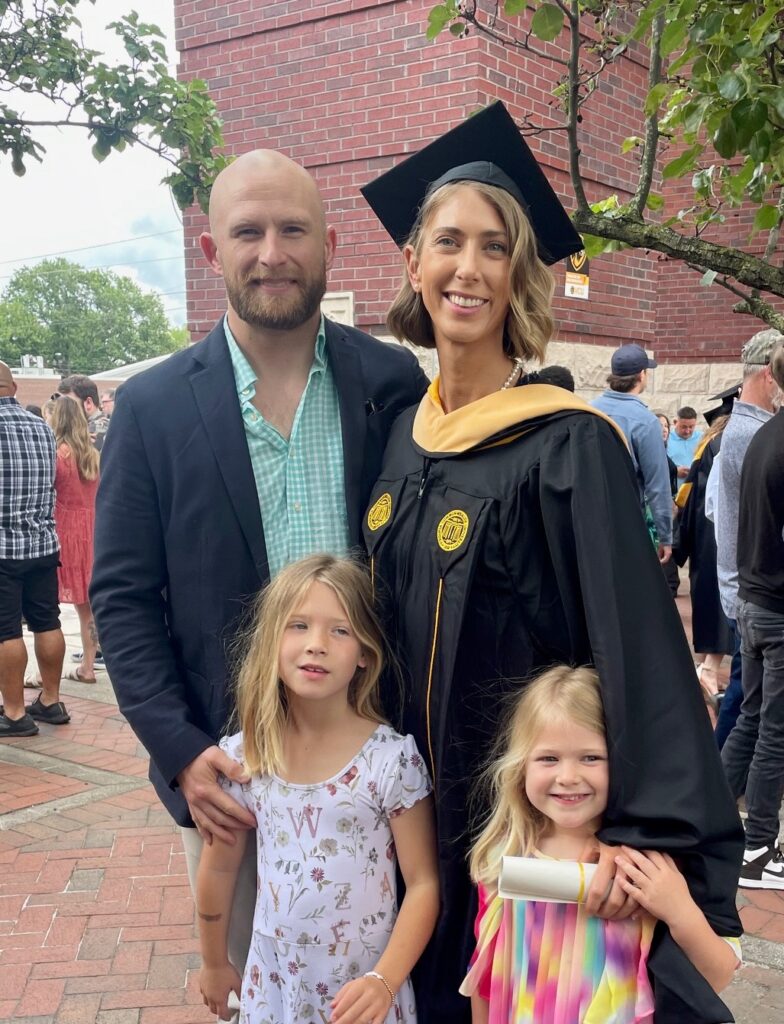 Photo of family standing outside posing for a photo. 