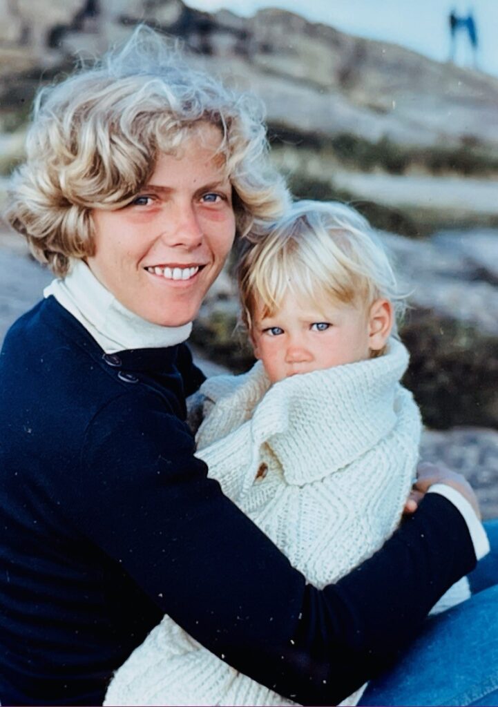 Photo of a young woman and girl posing for a photo on a cliffside rockface. 