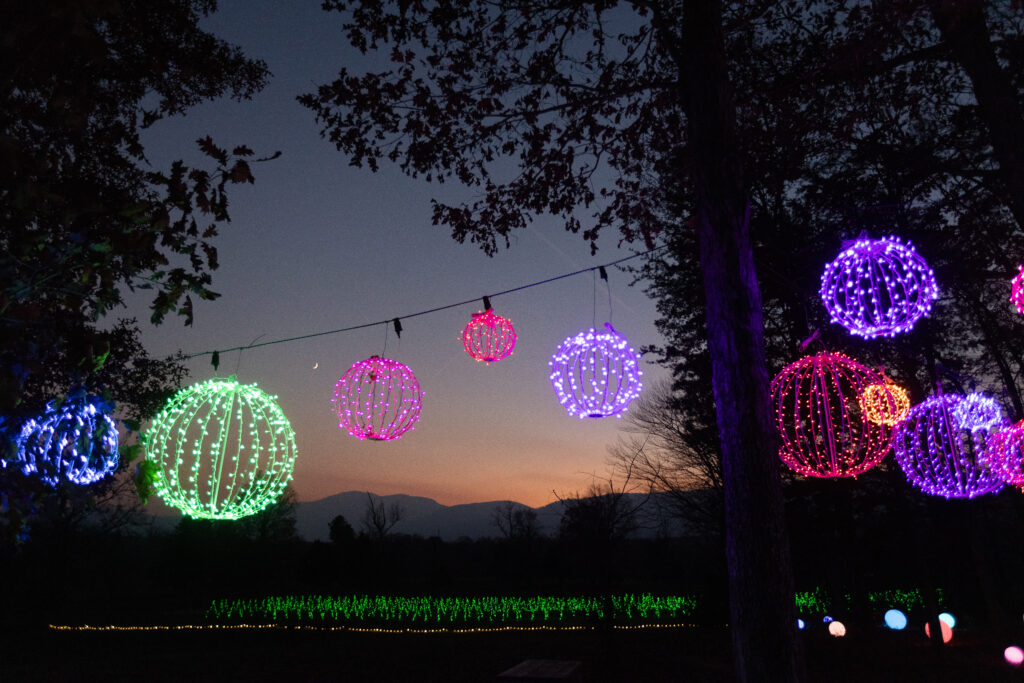 A photo of Veritas Illuminated at sunset hour with the Blue Ridge Mountainst in the background