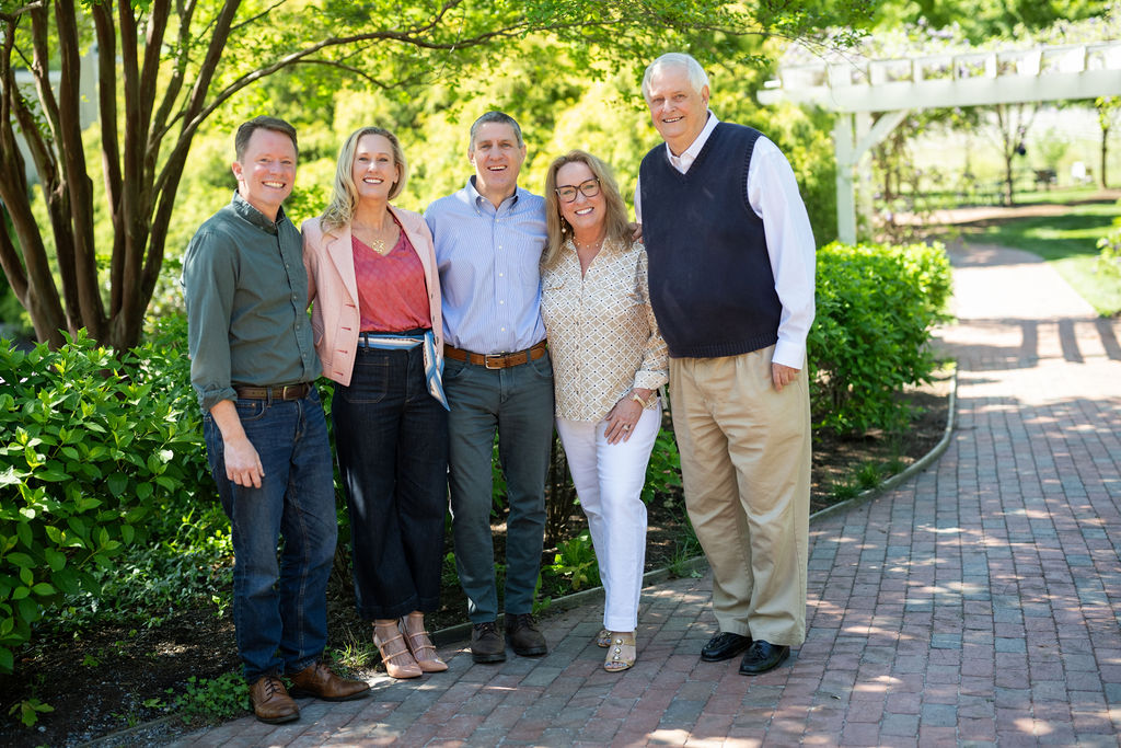 A group of five people stands in front of the entrance to Veritas Vineyard and Winery.